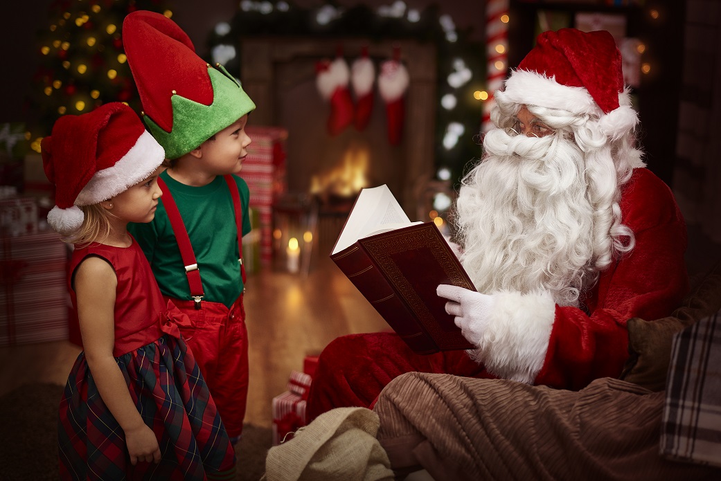 mysterious santa claus reading a book with children